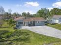 Charming single-story home with a well-maintained lawn and a spacious driveway at 2216 Umbrella Tree Dr, Edgewater, FL 32141