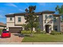 Stunning two-story home featuring lush landscaping, brick driveway, and a tile roof at 2344 Kelbrook Ct, Oviedo, FL 32765