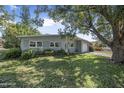 Well-kept single-story home featuring a lush green lawn and mature trees at 2821 Oak Lea Dr, South Daytona, FL 32119