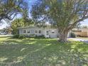 Single-story home featuring a lush green lawn and mature trees at 2821 Oak Lea Dr, South Daytona, FL 32119