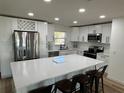 Modern kitchen featuring white cabinetry, stainless steel appliances, and a center island at 2929 Carriage Dr, South Daytona, FL 32119