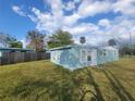 Exterior view of light blue single-story home with white trim, a door, and a spacious yard at 305 Elsie Ave, Daytona Beach, FL 32117