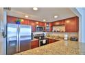 Well-appointed kitchen features granite counters, stainless steel appliances and cherry cabinets at 3051 S Atlantic Ave # 2206, Daytona Beach, FL 32118