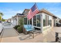 Inviting outdoor patio with comfortable seating and an American flag, perfect for relaxing or entertaining guests at 3102 Cordgrass Ct, The Villages, FL 32163