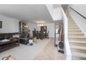Open-concept living and dining area with staircase and tile flooring at 3894 Arborvitae Way, Deland, FL 32724