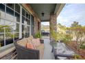 Covered porch with comfortable seating area and stone pillar accents at 3894 Arborvitae Way, Deland, FL 32724