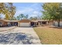 Charming single-story home featuring a two-car garage, stone accents, and a well-maintained front yard at 49 Crooked Pine Rd, Port Orange, FL 32128
