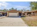 Charming single-story home featuring a two-car garage, stone accents, and a well-maintained front yard at 49 Crooked Pine Rd, Port Orange, FL 32128