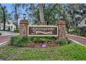 Greenspointe private community entrance with brick columns, beautiful landscaping, and a paved road at 509 Osprey Ln, Winter Springs, FL 32708