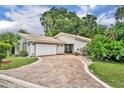 Single-story home boasting tile roof, paved driveway, and beautifully landscaped front yard at 509 Osprey Ln, Winter Springs, FL 32708