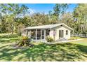 Inviting single-story home with a screened porch, lush lawn and mature trees in a serene setting at 53722 Rivertrace Rd, Astor, FL 32102