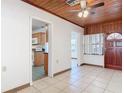 Living room featuring tile flooring, wooden ceiling, and entrance to kitchen area at 61 West Highbanks, Debary, FL 32713