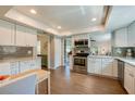 Bright kitchen featuring white cabinets, stainless steel appliances, and wood-look tile flooring at 901 Ponca Trl, Maitland, FL 32751