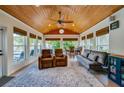 Relaxing sun room featuring a wood ceiling, floor-to-ceiling windows, and cozy seating at 901 Ponca Trl, Maitland, FL 32751