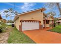 Single Gathering home featuring a two-car garage and charming front porch with decorative columns and a manicured lawn at 926 Sycamore St, Daytona Beach, FL 32114