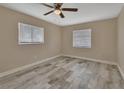 Cozy bedroom with ceiling fan, two windows, and wood-look tile flooring at 1033 Windbrook Dr, Deltona, FL 32725