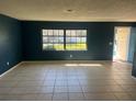 Bright living room with tile flooring, a large window, and a blue accent wall at 1096 N Harbor Dr, Deltona, FL 32725