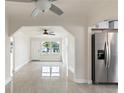 Bright living room with pristine white walls and tile floors offering a seamless transition to the kitchen area at 1135 Holly Ave, Daytona Beach, FL 32117
