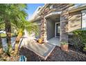 Close-up of a stone-clad front entrance with potted plants at 118 Grande Belfly Way, Daytona Beach, FL 32124