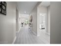 Bright hallway with light gray plank flooring, neutral walls, and views of the living room and bedroom at 118 Grande Belfly Way, Daytona Beach, FL 32124