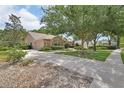 Attractive single-story home featuring mature trees, a two-car garage, and an American flag at 1491 W Silver Hammock, Deland, FL 32720