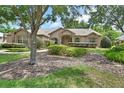 Charming single story home with lush landscaping, healthy green lawn, and mature trees at 1491 W Silver Hammock, Deland, FL 32720
