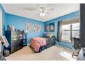 Cozy bedroom with blue walls, a ceiling fan, and a bright window that offers natural light at 1600 Big Tree Rd # E8, Daytona Beach, FL 32119