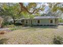 Charming single-story home with a covered porch surrounded by mature trees at 1712 Alanson Dr, Deland, FL 32724