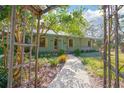 Charming home with covered porch framed by a decorative archway and lush greenery at 1712 Alanson Dr, Deland, FL 32724