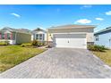 Wide driveway with stone pavers leading up to the home's attached garage, flanked by well-maintained lawns at 1716 Red Rock Rd, New Smyrna Beach, FL 32168
