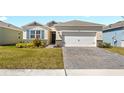 Charming single-Gathering home featuring a well-maintained lawn, an attached garage, and stone veneer accents at 1716 Red Rock Rd, New Smyrna Beach, FL 32168