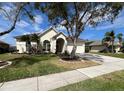 Inviting single-story home with a well-maintained yard, a tree and a driveway leading to a two-car garage at 1751 Creekwater Blvd, Port Orange, FL 32128