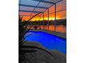 Screened-in pool with a vibrant sunset backdrop and water views at 1751 Creekwater Blvd, Port Orange, FL 32128