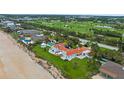 Aerial view of an oceanfront home close to a golf course with a pool and manicured lawn at 201 Ocean Shore Blvd, Ormond Beach, FL 32176