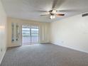 Bright living room with plush carpeting, sliding glass doors, and neutral decor at 202 Oakleigh Dr # 90, Deland, FL 32724