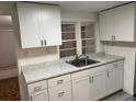 Bright kitchen with white cabinets, stainless steel sink, gray countertops and view out of the window at 333 8Th St, Daytona Beach, FL 32117