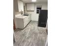 Cozy kitchen with white cabinets, stainless steel sink, gray countertops, and laminate flooring at 333 8Th St, Daytona Beach, FL 32117