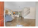 Bright, open-concept living room with stylish tile flooring, neutral walls, and stairs at 3346 Pegaso Ave, New Smyrna Beach, FL 32168