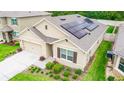 Aerial view of a charming single-Gathering home featuring solar panels, a manicured lawn, and a two-car garage at 339 Spruce Pine Dr, Debary, FL 32713