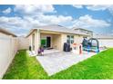 A spacious backyard with a paved patio, a small playhouse, and a trampoline at 339 Spruce Pine Dr, Debary, FL 32713