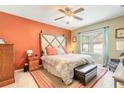 Cozy bedroom with colorful accent wall, decorative headboard, ceiling fan, and bright natural light at 347 Admiralty Ct, Edgewater, FL 32141