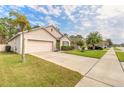 Inviting home exterior with a lush lawn, palm tree, two-car garage, and ample driveway space at 347 Admiralty Ct, Edgewater, FL 32141