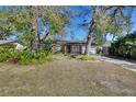 Single-story brick home featuring mature trees, landscape, and a paved driveway at 351 W Holly Dr, Orange City, FL 32763