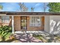 Close up of the brick home featuring a glass front door and lush greenery at 351 W Holly Dr, Orange City, FL 32763