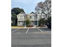 Townhome complex with gray siding, blue doors, and parking lot in front at 3960 Willow Trail Run # 45, Port Orange, FL 32127