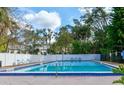 Refreshing blue swimming pool with a white fence, palm trees, and lounge chairs, perfect for relaxing outdoors at 3960 Willow Trail Run # 45, Port Orange, FL 32127
