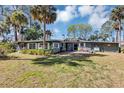 Spacious backyard featuring a well-maintained lawn, trees, and a patio area with seating at 4282 Alice St, Edgewater, FL 32141