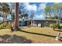 Spacious backyard featuring a well-maintained lawn, trees, and a patio area with seating at 4282 Alice St, Edgewater, FL 32141