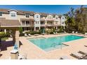 Community pool with lounge chairs, umbrellas, and nearby townhome exteriors in a serene setting at 471 Portico Ct, Oviedo, FL 32765