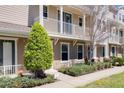 Two-story townhome with a covered porch, balcony, and well-maintained front yard landscaping at 471 Portico Ct, Oviedo, FL 32765